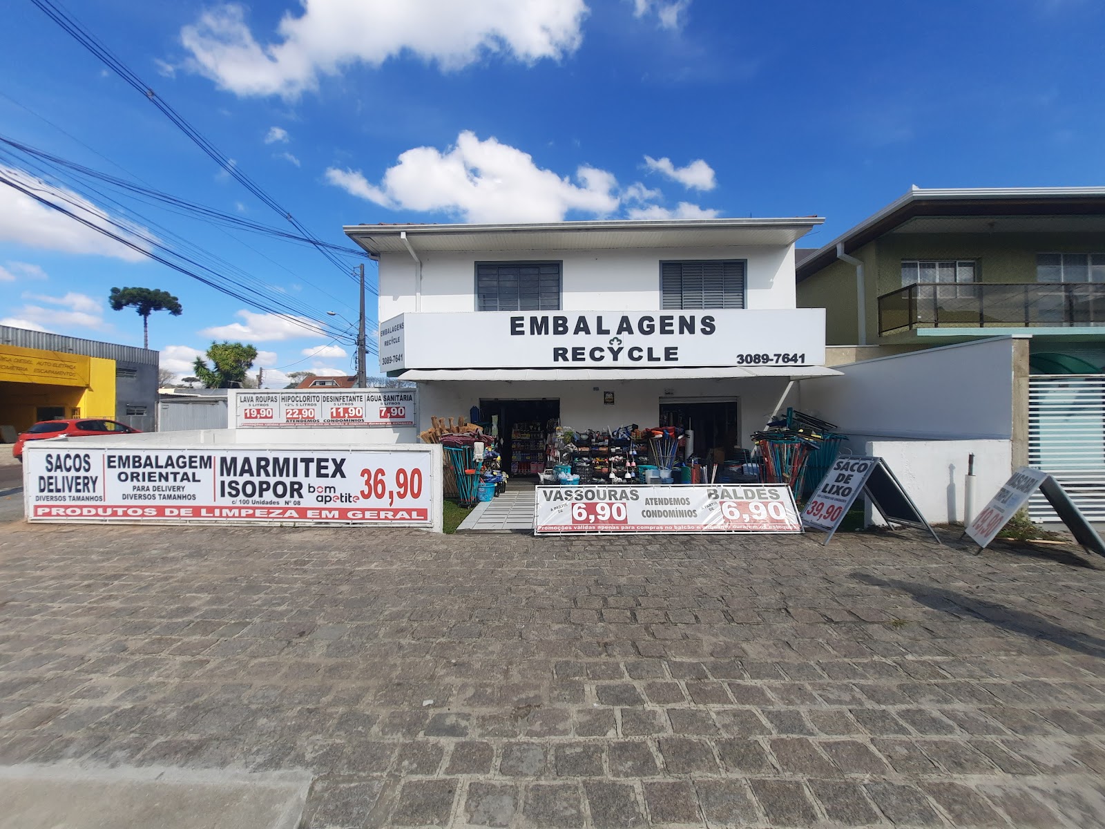 Fachada da loja Embalagens Recycle, com faixas de ofertas na calçada